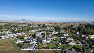 Aerial view of property and surrounding area with nearby suburban area and a mountainous background