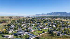 Aerial view of property and surrounding area with nearby suburban area and a mountainous background
