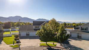 Traditional home with stone siding, a mountain view, and driveway