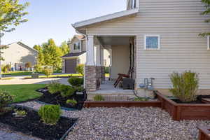 View of exterior entry with covered porch and driveway
