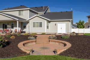 Rear view of house with roof with shingles and a patio area
