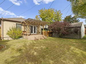 Back of house featuring a pergola and roof with shingles