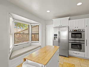 Kitchen featuring white cabinetry, appliances with stainless steel finishes, and recessed lighting.