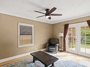 Sitting room with french doors, wood flooring, ornamental molding, a textured ceiling, and a ceiling fan