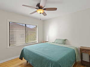 Bedroom with wood floors and a ceiling fan