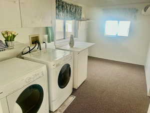 Laundry room with light carpet, washer and clothes dryer, and cabinet space
