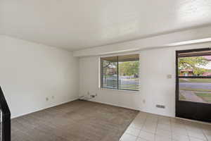 Foyer with light tile patterned floors and light colored carpet