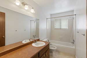 Bathroom with bathing tub / shower combination, vanity, and light tile patterned floors