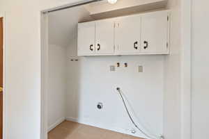 Washroom featuring cabinet space, light tile patterned floors, gas dryer hookup, and hookup for a washing machine