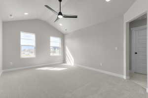 Empty room featuring lofted ceiling, light carpet, a ceiling fan, and recessed lighting