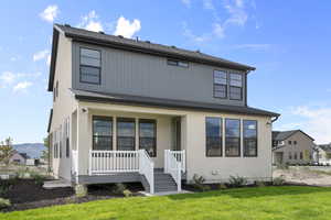 View of front of home with a front lawn, a porch, and stucco siding