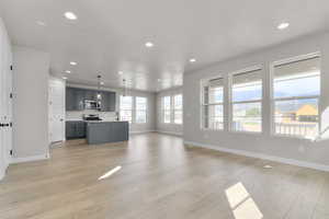 Unfurnished living room with recessed lighting, light wood finished floors, and a mountain view