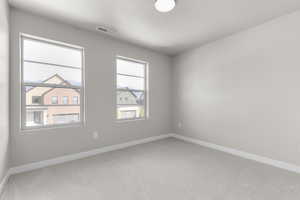 Unfurnished room with light carpet and a textured ceiling