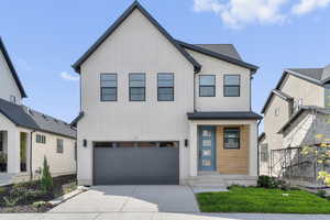 Modern inspired farmhouse featuring a garage and driveway