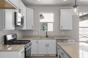 Kitchen with appliances with stainless steel finishes, white cabinets, healthy amount of natural light, and recessed lighting