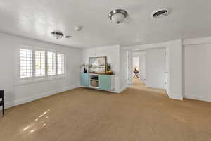 Large family room down with built-in cabinet, plantation shutters and lots of natural light.