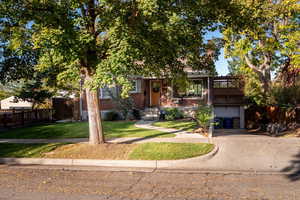 View of property featuring brick siding, driveway, and an attached garage