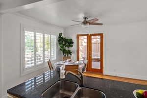 Semi-formal dining area featuring crown molding, ceiling fan, hardwood floors and French doors out to the deck.
