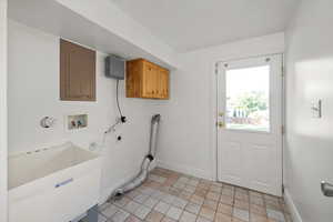 Laundry with a laundry sink and the door to access the backyard.