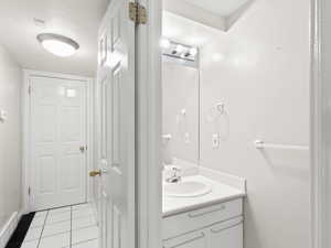Bathroom with light tile patterned floors and vanity