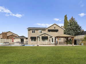 Back of property featuring a patio area, a gazebo, a fenced backyard, a storage shed, and stucco siding