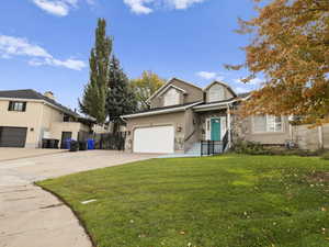 Traditional-style house with a garage, concrete driveway, and stone siding