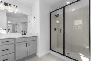 Bathroom featuring light tile patterned flooring, vanity, a stall shower, and recessed lighting