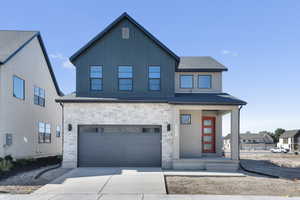 View of front of home with an attached garage, stone siding, covered porch, driveway, and roof with shingles