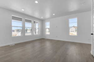 Unfurnished room with wood finished floors and recessed lighting