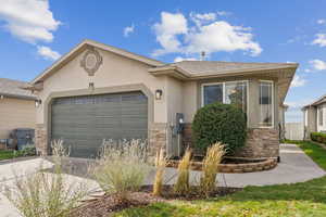Single story home with stone siding, stucco siding, driveway, and a shingled roof