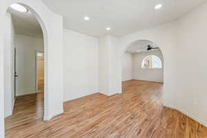 Spare room featuring arched walkways, recessed lighting, light wood finished floors, and a ceiling fan