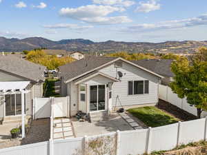 View of property with a gate, a fenced backyard, a patio, and a mountain view