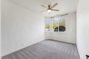Carpeted empty room with baseboards and a ceiling fan