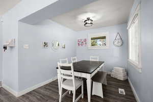 Dining space featuring baseboards and dark wood-type flooring