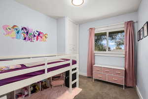 Bedroom featuring dark carpet and baseboards