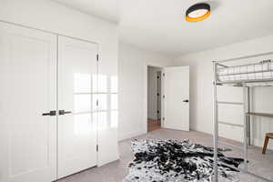 Unfurnished bedroom with light colored carpet and a closet