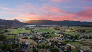 View of mountain backdrop with rural landscape and a large body of water