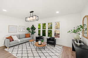 Living room with light wood finished floors and recessed lighting