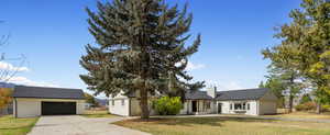 View of front of home with an outbuilding, a front yard, driveway, and a garage