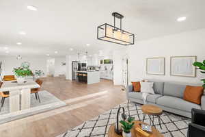 Living area with recessed lighting and light wood-style flooring