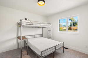 Bedroom featuring carpet floors and baseboards