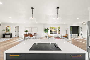 Kitchen with light wood-type flooring, open floor plan, light stone counters, and recessed lighting