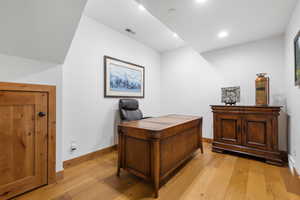 Office space featuring light wood-type flooring and recessed lighting