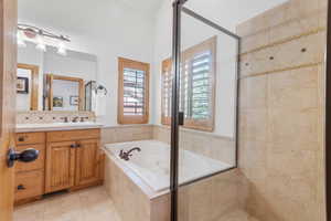Full bathroom with vanity, a jetted tub, light tile patterned flooring, decorative backsplash, and a tile shower
