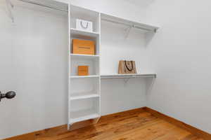 Walk in closet with light wood finished floors