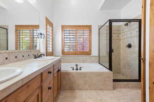Bathroom with a stall shower, a garden tub, and double vanity