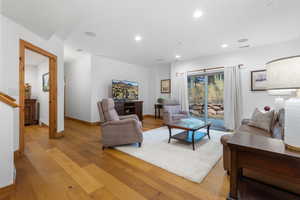 Living area with light wood finished floors and recessed lighting