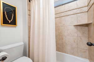 Full bath featuring shower / bath combination with curtain and toilet