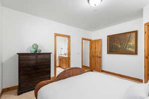 Bedroom featuring baseboards and ensuite bathroom