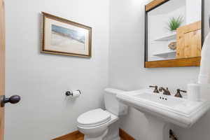 Half bath featuring toilet and baseboards